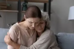 Aged,retired,female,mother,hold,in,arms,embrace,tight,upset