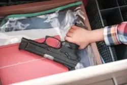 Child,takes,a,pistol,in,a,drawer,of,a,nightstand