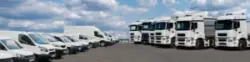 Semi,trucks,and,delivery,vans,are,parked,in,rows