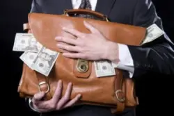 Closeup,of,man,holding,briefcase,with,money,spilling,out,close