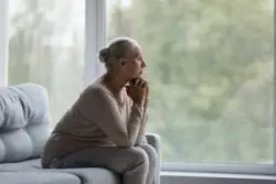 Pensive,old,mature,woman,looking,in,distance,out,of,window,
