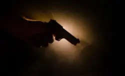 Shadowed man holding a firearm