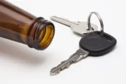 Mouth of open bottle and car keys