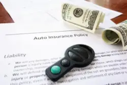 Auto insurance policy, money and key