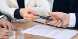Woman handing pen to man